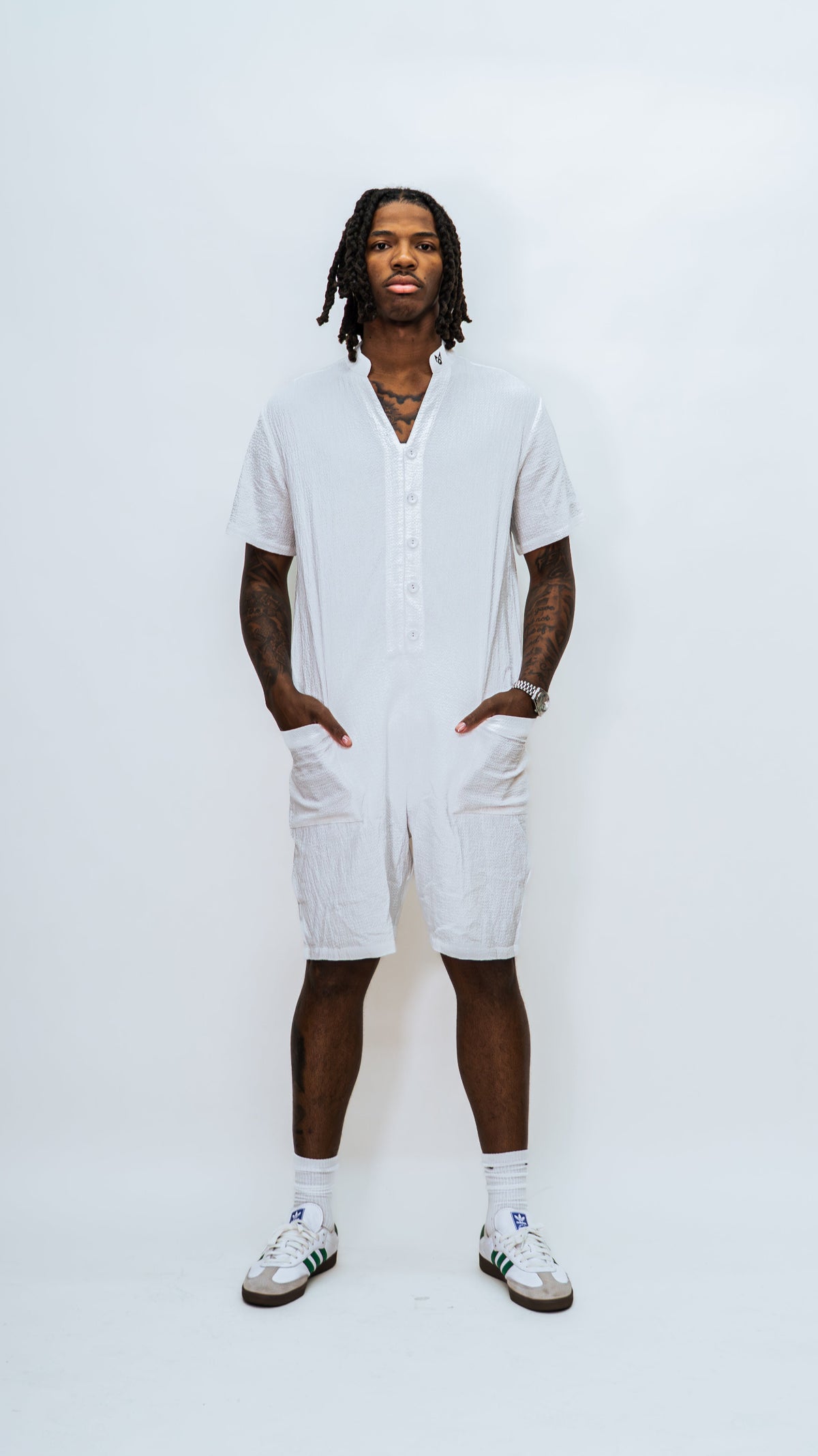 A model wearing the Milkwhite jumpsuit button down slightly opened and facing forward.