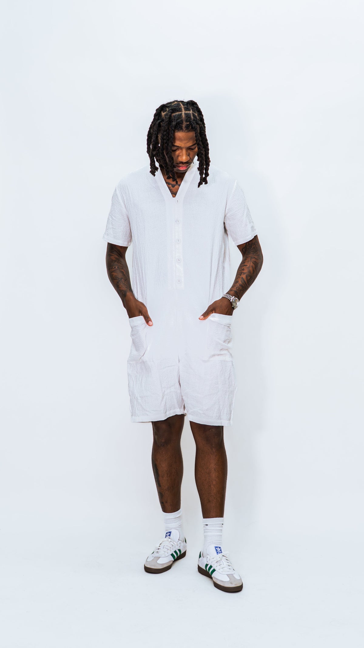 Person wearing a milkwhite white button down comfortable jumpsuit on a white background.