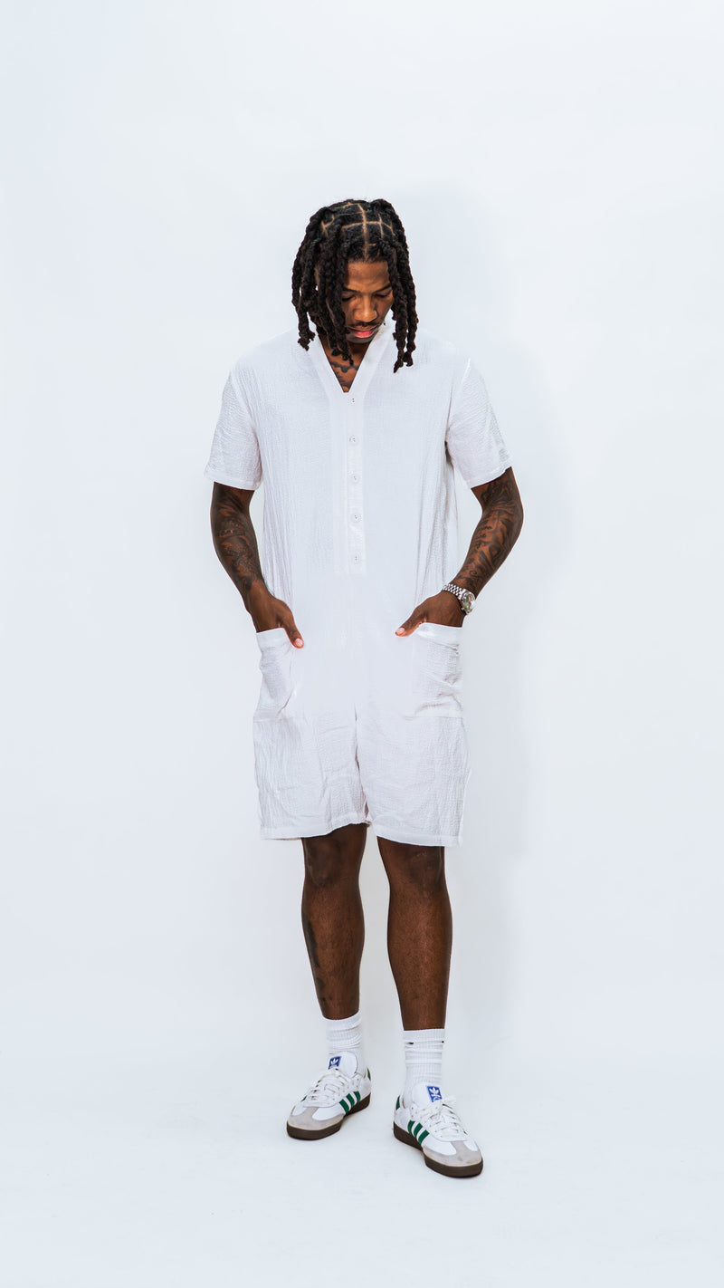 Person wearing a milkwhite white button down comfortable jumpsuit on a white background.