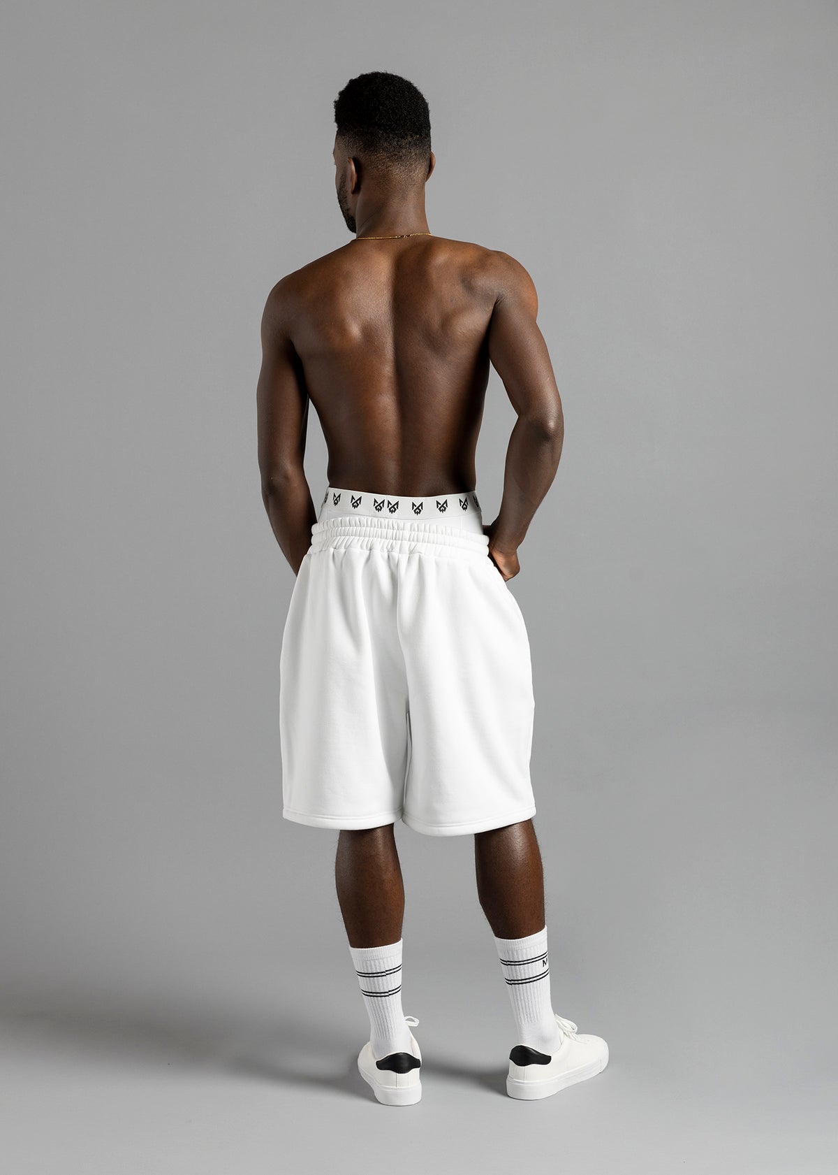 Full-length back view of a model wearing MilkWhite Jogger Shorts, showing the gathered waist and wide legs.