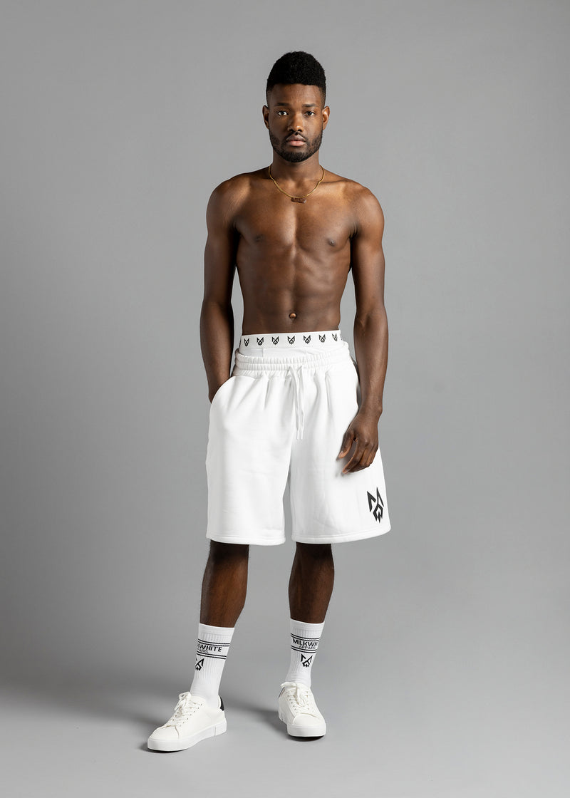 Full-length front view of a model wearing MilkWhite Jogger Shorts, with a drawstring waist and black logo on the leg.