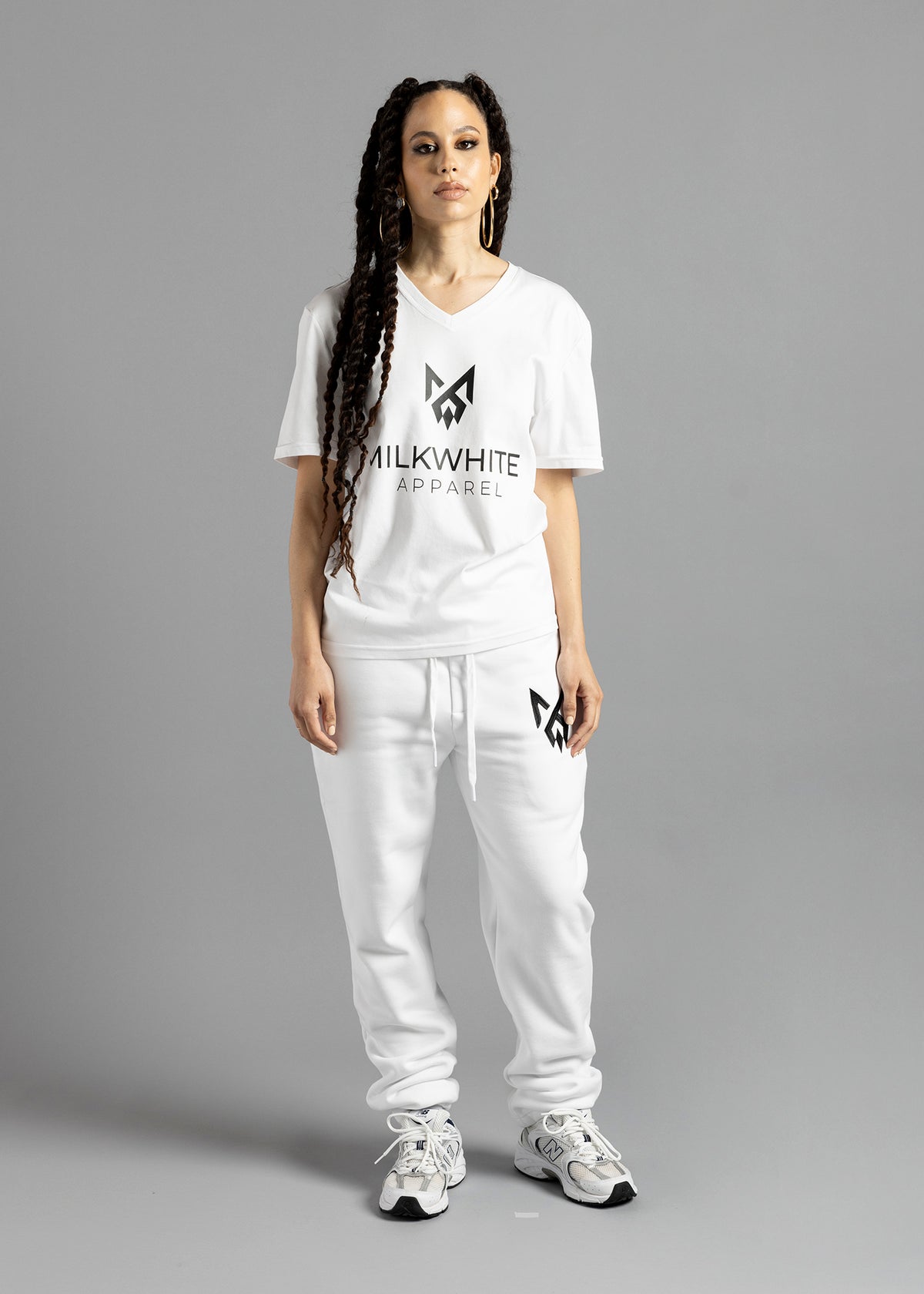 Full-length front view of a model wearing the white MilkWhite Premium T-Shirt, with a V-neck, short sleeves and dark chest logo and lettering.
