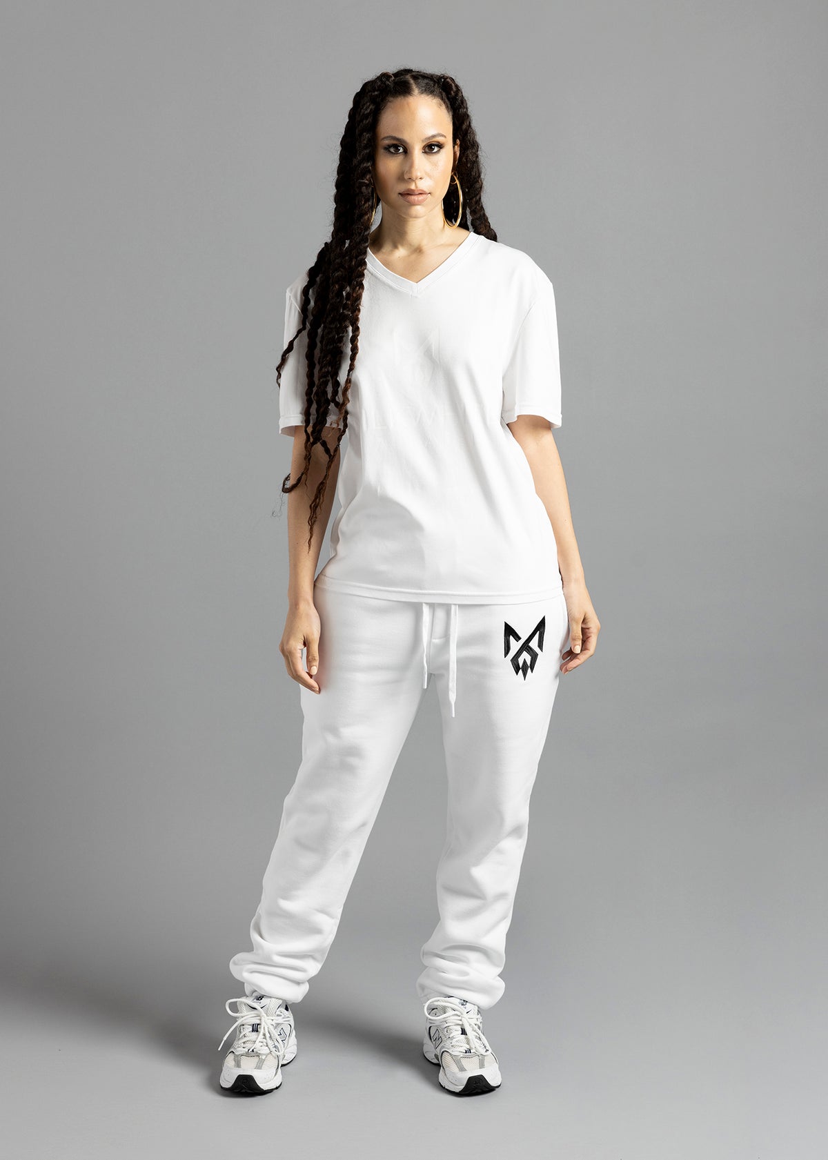 Full-length front view of a model wearing the white MilkWhite Premium T-Shirt, showing the V-neck, short sleeves and white-on-white chest design.