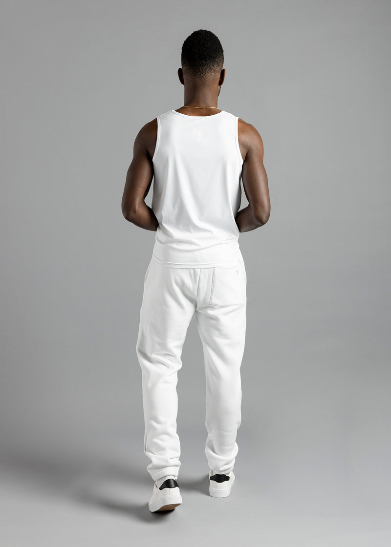 Full-length rear view of a model wearing the white MilkWhite Premium Tank Top with white joggers.