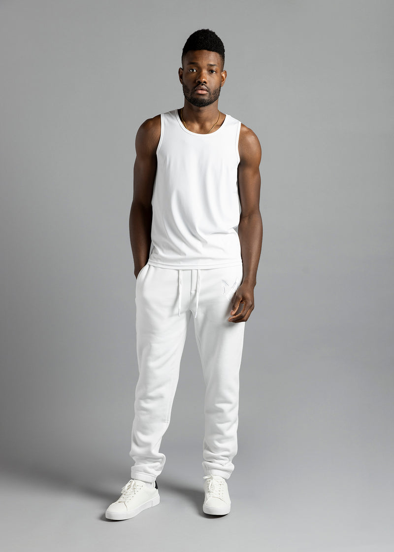 Full-length front view of a model wearing the white MilkWhite Premium Tank Top with white drawstring joggers.