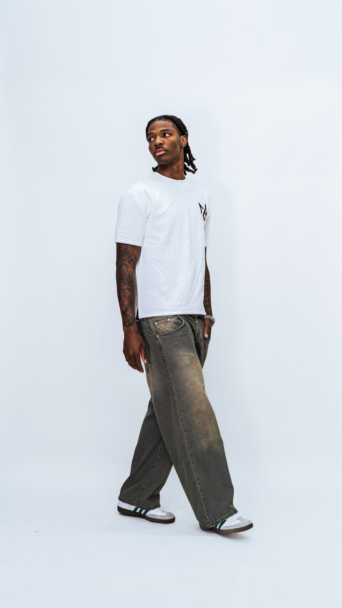 Three-quarter front view of a model wearing the white MilkWhite Short Sleeve Sweatshirt with a black chest logo.