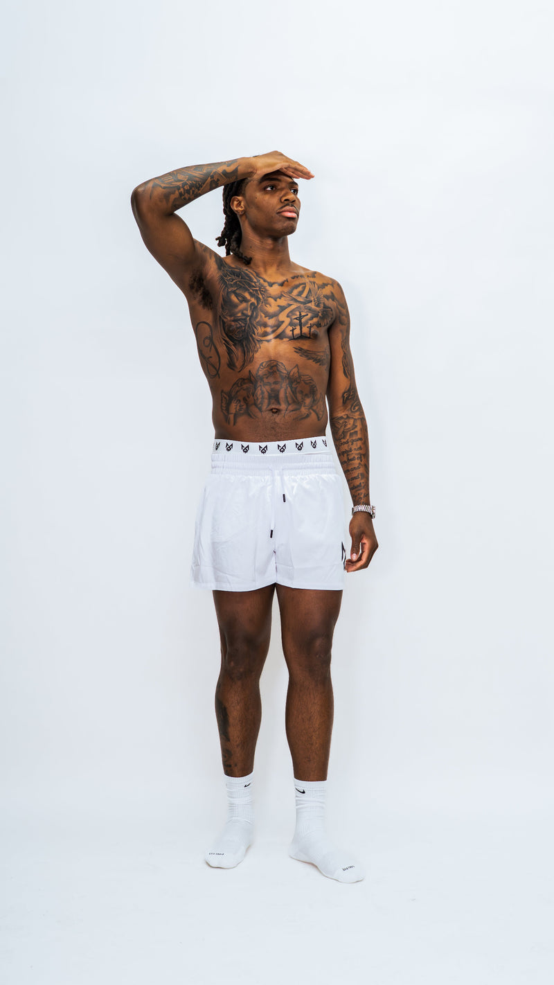 Model wearing Milkwhite Short swim trunks casually against a white background.