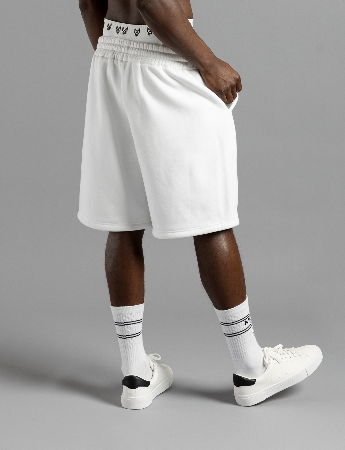Three-quarter rear view of MilkWhite White Socks worn with white sneakers, showing black stripes around the cuffs.