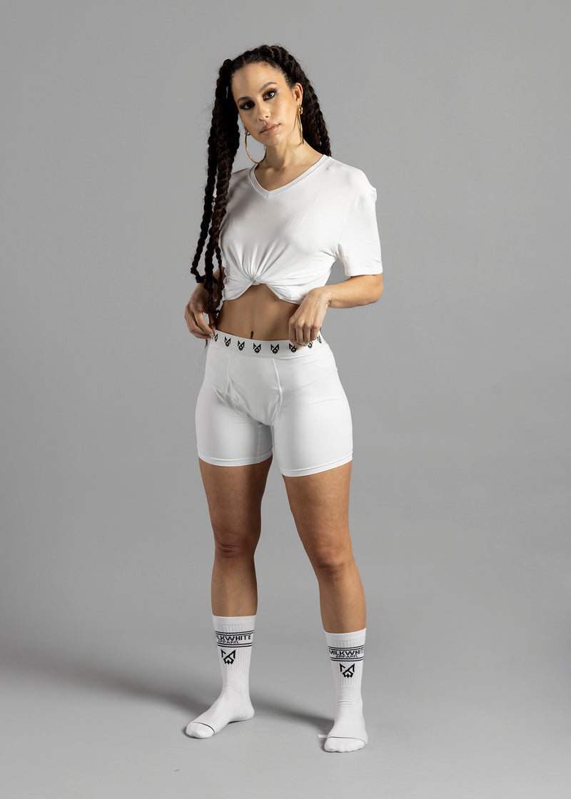 Full-length front view of a model wearing MilkWhite White Socks, with the black cuff lettering and logos visible.