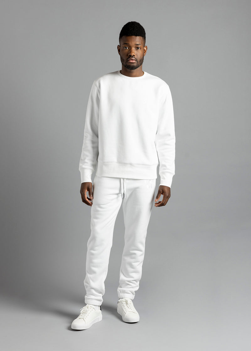 Full-length front view of a model wearing the white Milk Essential Sweatshirt by MilkWhite, showing its crew neckline, long sleeves and ribbed hem.