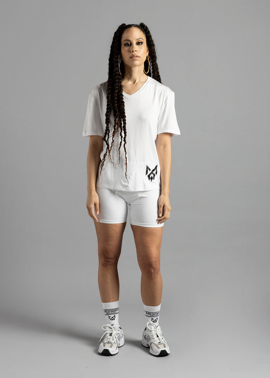 A woman wearing a white Milk Under t-shirt with logo on bottom left, MilkWhite Briefs, and MilkWhite socks.