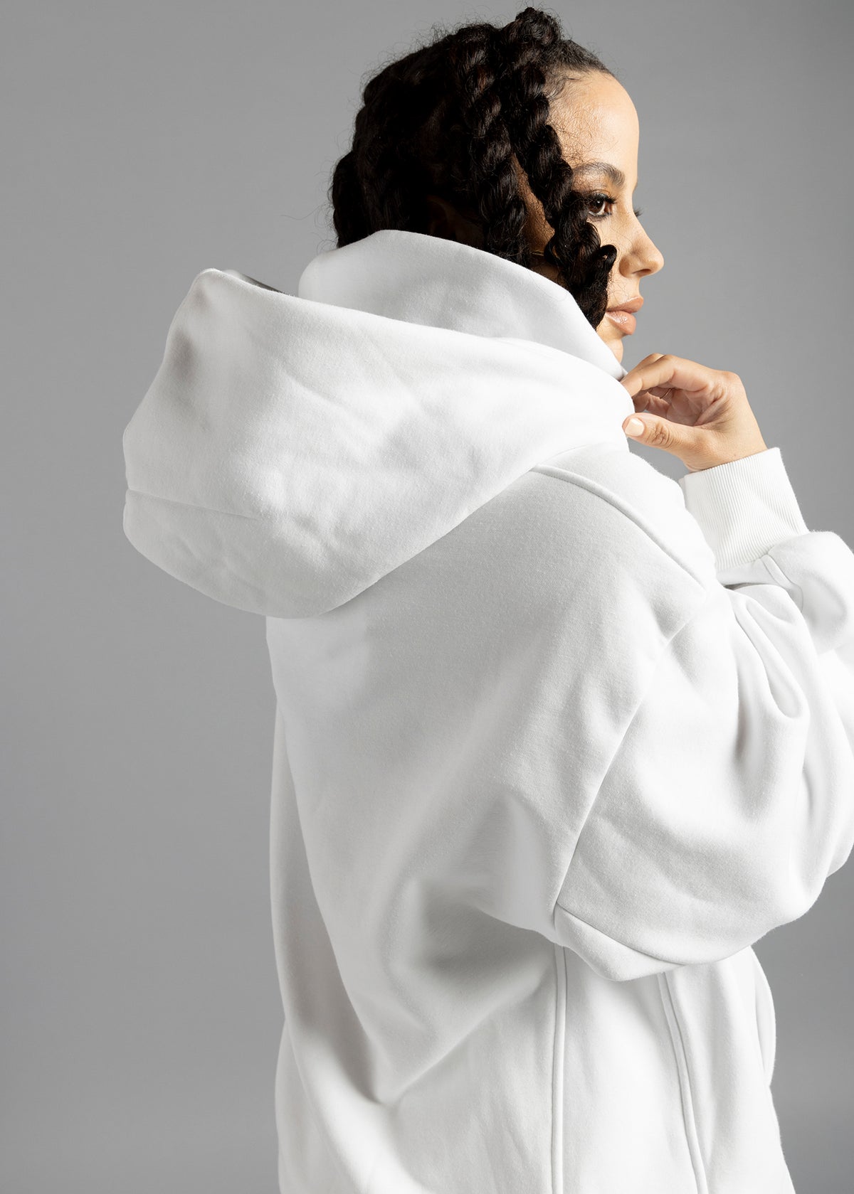 Three-quarter rear close-up of the white Rosebud Hoodie by MilkWhite, showing the hood resting on the upper back.